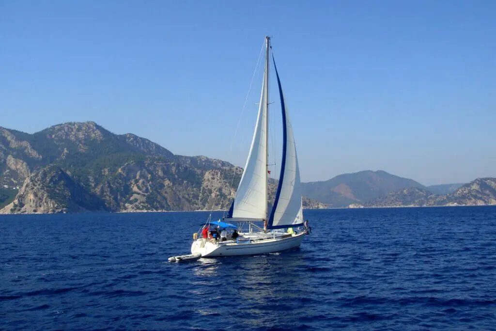 yacht-with-white-sail-sailing-on-a-calm-sea-on-a-b-2022-05-11-22-46-02-utc-1024x683